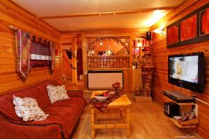 sala de estar con sofá y TV en Under the Walnut Tree Shade Lodge en Adi
