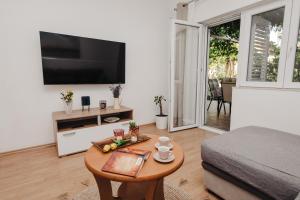 a living room with a coffee table and a television at Apartman Branko in Zaboric