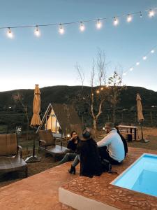 a group of people sitting on a patio with a tent at The Pangea Valle de Guadalupe in Valle de Guadalupe