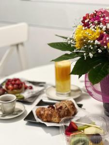 una mesa cubierta con platos de comida y un jarrón de flores en Prestige Rooms Chiaia, en Nápoles