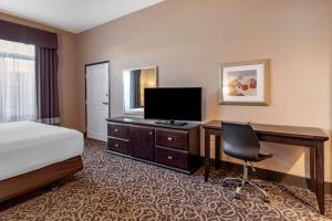 a hotel room with a bed and a desk with a television at Best Western Plus Las Vegas South Henderson in Las Vegas