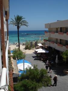 - une vue sur la plage avec un bâtiment et l'océan dans l'établissement Formentera suite 13, à Es Pujols