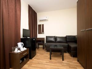 a living room with a couch and a television at Hotel Golden Ina - All Inclusive - Beachfront in Sunny Beach