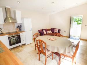 a kitchen and dining room with a table and chairs at Moorlands Farm Cottage in Foxt