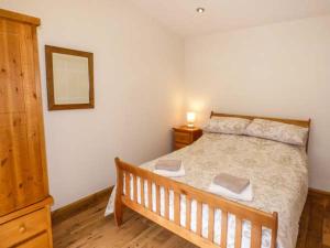 a bedroom with a bed and a dresser and a mirror at Moorlands Farm Cottage in Foxt