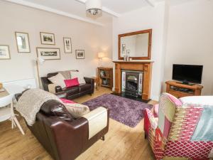 een woonkamer met een bank en een open haard bij Cottongrass Cottage in Littleborough