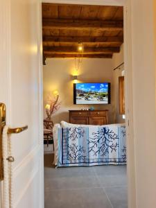Zimmer mit einem Tisch und einem TV an der Wand in der Unterkunft Residence Cala Francese - Case sul mare in La Maddalena