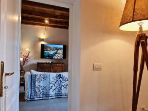 - un couloir avec une porte menant à une chambre dotée d'une télévision dans l'établissement Residence Cala Francese - Case sul mare, à La Maddalena