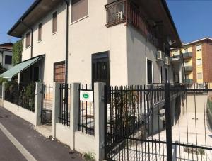 une clôture devant un bâtiment avec une maison dans l'établissement Appartamento affitti brevi Verona Colors/G.B. Rossi friendly, à Vérone