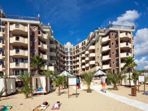 a hotel on the beach with people on the sand at Hotel Golden Ina - All Inclusive - Beachfront in Sunny Beach