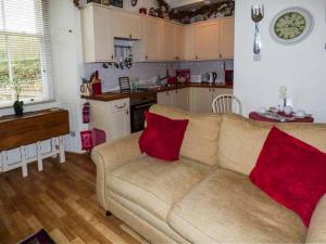 a living room with a couch with two red pillows at 3 Queen Marys Buildings in Jedburgh
