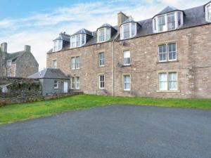 a large brick building with a driveway in front of it at 3 Queen Marys Buildings in Jedburgh