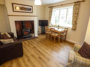 a living room with a table and a fireplace at Littlebeck in Rosthwaite