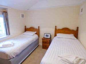 a bedroom with two beds and a table with a picture at Littlebeck in Rosthwaite