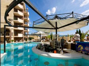 a pool at a resort with an umbrella at Hotel Golden Ina - All Inclusive - Beachfront in Sunny Beach