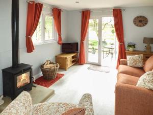 a living room with a couch and a fireplace at Park Brook Retreat in Scorton