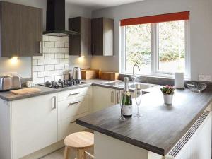 a kitchen with a counter with a bottle of wine on it at Park Brook Retreat in Scorton