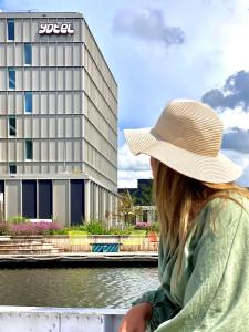 a woman wearing a hat standing in front of a building at YOTEL Amsterdam in Amsterdam