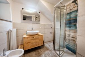 een badkamer met een wastafel en een glazen douche bij Cà Rosa in Mergozzo