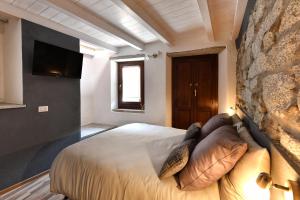 een slaapkamer met een bed en een tv aan de muur bij Cà Rosa in Mergozzo