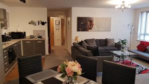 a living room with a couch and a table at Cosy 2 bedroom Apt with Fast Wi-Fi & Free Parking in Manchester