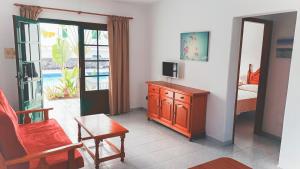 a living room with a tv and a chair and a table at Apartamentos Aloe in Puerto del Carmen +52 photos