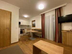 un soggiorno con tavolo e cucina di Der Brückenhof Ramsau a Ramsau am Dachstein