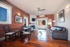 a living room with a couch and a table at The Bank Apartment - Echuca Holiday Homes in Echuca