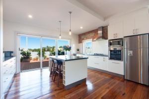 a kitchen with white cabinets and stainless steel appliances at The Bank Apartment - Echuca Holiday Homes in Echuca
