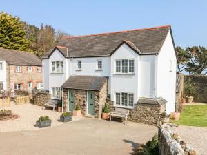 a large white house with a courtyard at Kingfisher Cottage in Ilfracombe