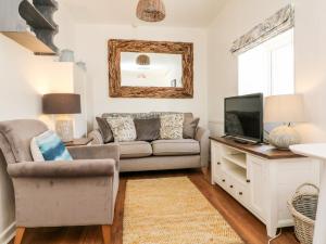 ein Wohnzimmer mit Sofa und Fernseher in der Unterkunft Robin Cottage in Ilfracombe