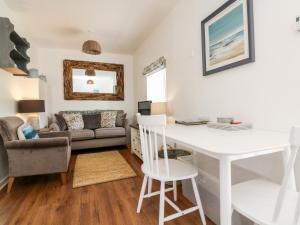 uma sala de estar com uma secretária branca e um sofá em Robin Cottage em Ilfracombe