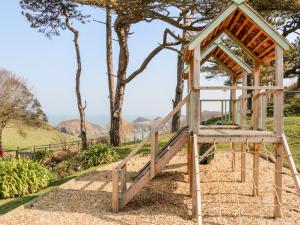 ein hölzerner Pavillon in einem Park mit einem Baum in der Unterkunft Robin Cottage in Ilfracombe