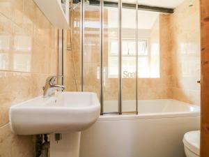 ein Badezimmer mit Waschbecken und Badewanne in der Unterkunft Pheasant Cottage in Ilfracombe + 18 Fotos