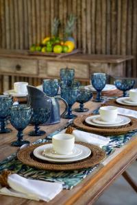 una mesa de madera con platos y tazas en la parte superior en Casa Das Águas Trancoso, en Trancoso