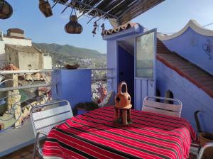 uma sala de jantar com uma mesa com uma toalha de mesa listrada em vermelho e branco em Dar Lalla chafia 2 em Chefchaouen