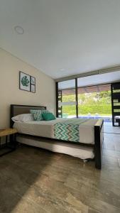 a bedroom with a large bed and a large window at Finca los Colores in Villavicencio