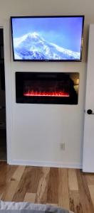 a flat screen tv on a wall with a fireplace at Nature Lovers Getaway in Flagstaff