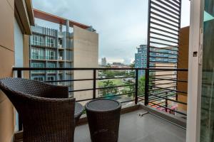 balkon z 2 krzesłami i widokiem na miasto w obiekcie Honey Inn Pattaya w mieście Pattaya Central