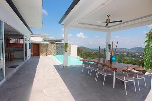 a patio with a table and chairs and a pool at Villa Melissa Samui Sea View in Bophut 