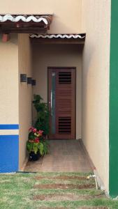 une porte d'entrée d'une maison avec deux plantes dans l'établissement Loft amplo, apenas 6km do Morro do Careca! (G), à Natal