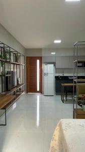 a large kitchen with a refrigerator and a table at Loft amplo, apenas 6km do Morro do Careca! (G) in Natal