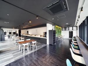 a restaurant with tables and chairs and a counter at CHISUN STANDARD Osaka Shin-Imamiya in Osaka