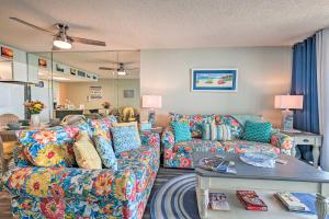 uma sala de estar com um sofá e uma mesa em Oceanfront Oasis with Deck and Resort Beach Access! em Myrtle Beach