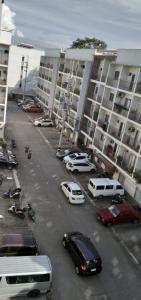 a parking lot with cars parked in front of large buildings at Kdorzmoonwalk Kassel Residences Paranaque in Manila