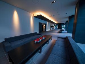 a living room with a couch and a table at CHISUN STANDARD Osaka Shin-Imamiya in Osaka +62 photos