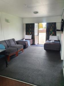 sala de estar con 2 camas y sofá en Ohakune Court Motel, en Ohakune