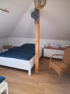 um quarto com uma cama e uma cadeira em eMKa Noclegi apartamenty em Augustów