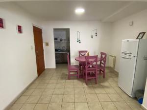 Una cocina con mesa y sillas y un refrigerador. en Departamento Belgrano 12, en Salta