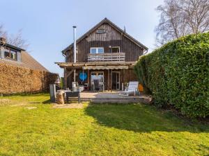 a wooden house with a porch and a deck at Comfortable apartment in Monschau H fen with private garden in Alzen